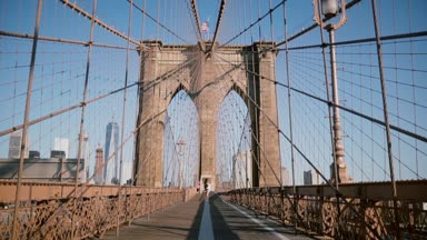 Her diğer, elele Brooklyn köprüsünde bir yaz gününde kamera için çalıştırın tutan genç Avrupa romantik çift spin.