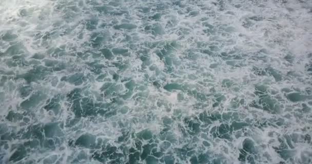 Drone voando sobre ondas espumantes quebrando em mar azul aberto, revelando horizonte nublado. Fundo bonito da espuma do oceano . — Vídeo de Stock