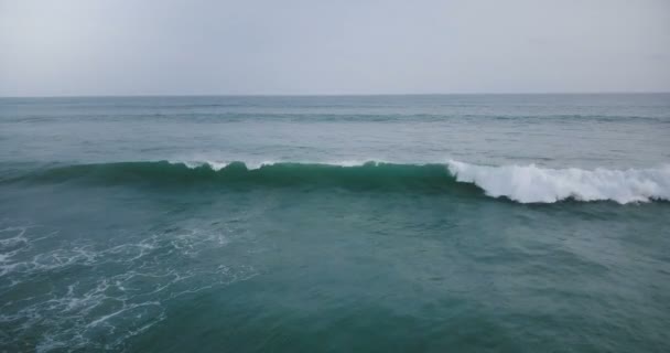 Vue aérienne par drone de la marée des grandes vagues océaniques s'écrasant et moussant dans l'océan ouvert bleu à couper le souffle, le paysage marin et les toits .