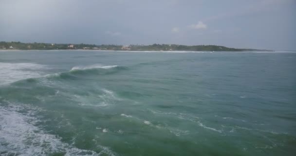 Drone caméra tourne à gauche pour suivre énorme vague de l'océan atteignant la plage tropicale paisible et s'écrasant avec une belle mousse . — Video