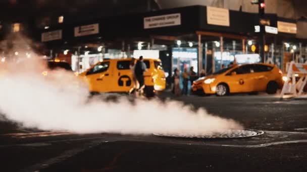 Close-up view of manhole cover with flying smoke, fume on the traffic road in downtown of New York, America. — Stock Video