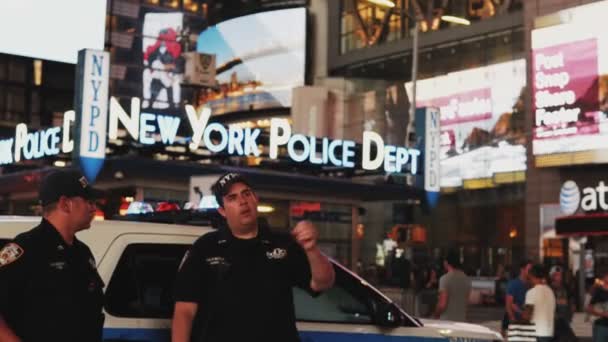 NEW YORK, États-Unis, 18.08.2017 Deux policiers se tiennent sur la place du Temps à New York, en Amérique et parlent, regardant sur la route de la circulation — Video