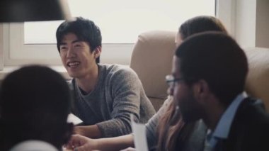 Yavaş hareket toplantı çok ırklı ofiste gülümseyen mutlu emin Japon genç işadamı paylaşım fikirler, serbest.