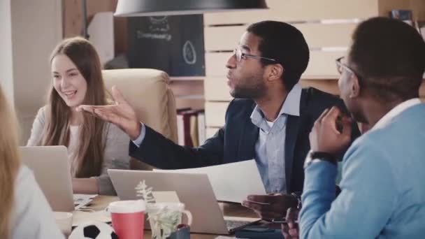 Glad afroamerikansk firmaleder som leder den kreative diskusjonen på flerkulturelt møte på loftskontoret sakte film . – stockvideo