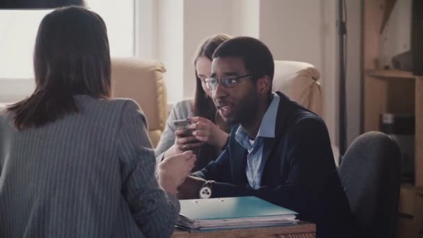 Junge afrikanisch-amerikanische Mitarbeiterin hört bei modernem Büro-Business-Meeting Zeitlupe auf unkenntliche Führungspersönlichkeiten. — Stockvideo