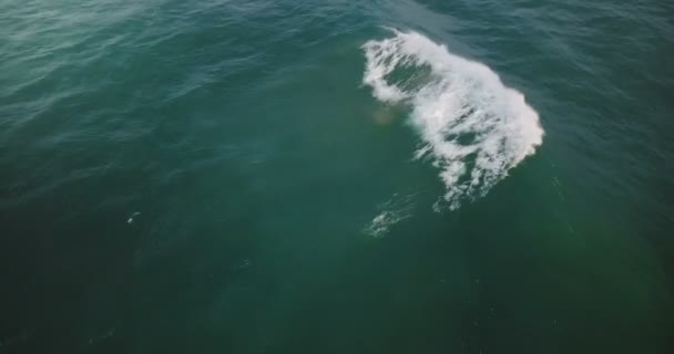 Drone flying low over high foaming waves in open ocean. Peaceful vertical view of blue tides breaking over sea water. — Stock Video