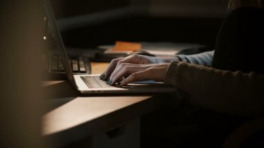 Yakın çekim Kadın el dizüstü karanlıkta kullanma. Kadın defter klavyede yazarak. Mobil ofis online. Yan görünümü 4k.