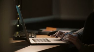 Geceleri bir dizüstü bilgisayar ile çalışan yakın çekim kadın. Defter touchbar ve trackpad'i kullanarak eller. İşkolik. 4k.