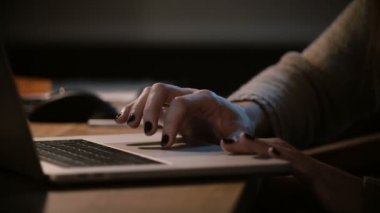 Dizüstü iz ve touchbar geceleri kullanan kız. Yakın çekim. Bilgisayar touchpad üzerinde eller. Geç saatlere kadar evde. 4k.