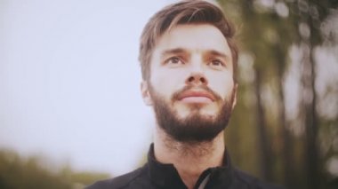 4k emin gülümseyen Avrupa adam portresi. Düşük açısı shot kapatın. Sakallı yakışıklı adam geleceğe olumlu bakış.