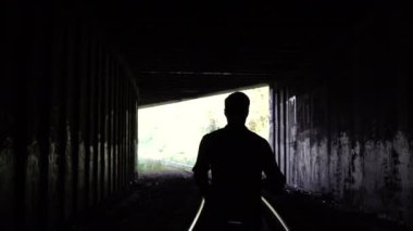 4 k kayıp adam siluet çalıştırır karanlık tünel çıkış için. Arkadan görünüm. Soyut siluet vurdu. Kaçış. Sorunlar ve depresyon.