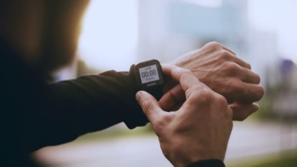 4K Runner iniciando reloj inteligente temporizador y funcionando. Hombre revisando el monitor de frecuencia cardíaca antes de correr. Estilo de vida POV disparo . — Vídeos de Stock