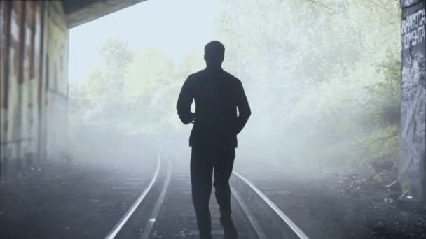 4k Mann läuft schnell auf nebligen Bahngleisen davon. Rückseite. abstraktes Hintergrundbild. Kreativer Lifestyleläufer erschossen. — Stockvideo