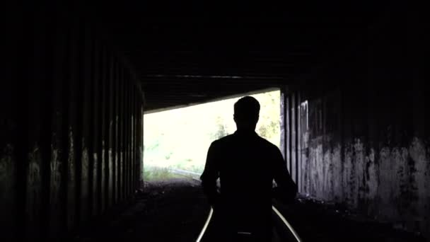 4 k förlorade man silhuetten går till mörk tunnel exit. Bakifrån. Abstrakta siluett sköt. Fly. Problem och depression. — Stockvideo