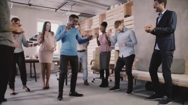 Funcionário afro-americano feliz dançando com colegas na festa de escritório, celebrando a realização de negócios câmera lenta . — Vídeo de Stock
