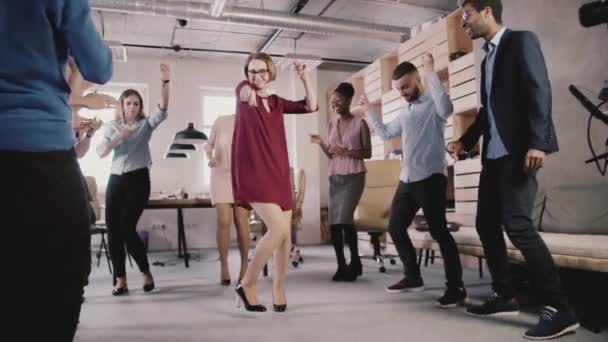 Feliz líder mujer caucásica bailando en la fiesta informal de la oficina. Gente de negocios multiétnicos celebran éxito cámara lenta . — Vídeo de stock