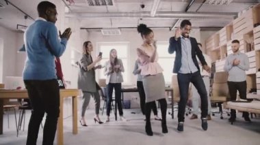 Eğlenceli etnik gösterilen iki Afro-Amerikan iş adamları office başarı kutlama parti yavaş hareket dans hareketleri.