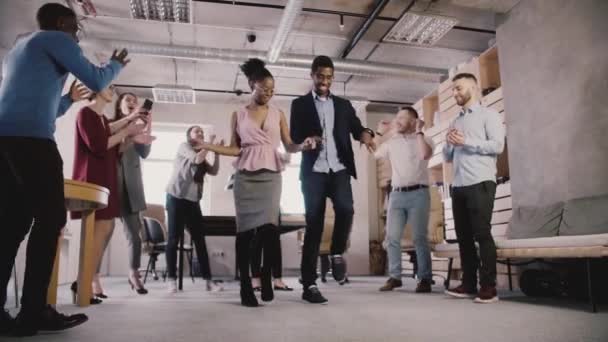 Multiethnic business people celebrate business achievement at casual office dance party in modern coworking slow motion. — Stock Video
