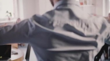 Mutlu heyecanlı işadamı komik kutlama dansı yapan modern ofise yürüyor, çok etnik gruptan oluşan işçi ağır çekim alkış.