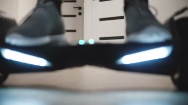 Erkek spor ayakkabı gyroscooter dairede, geriye doğru sürme ve çekip üzerinde adım bacaklarda yakın çekim düşük açılı çekim