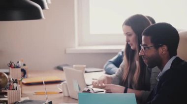 Mutlu çok ırklı bin yıllık iş adamları birlikte modern hafif çatı sağlıklı ofis, yavaş hareket tablosunda tarafından çalışır.