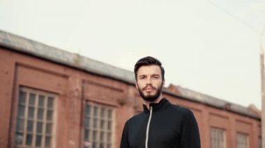 Gülümseyen portresi ve kendinden emin beyaz adam. Düşük açılı yavaş yakından atış kaydırma yakışıklı erkek yüzü sakallı.