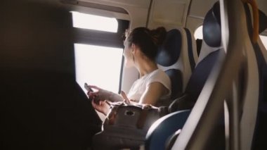 Bir akıllı telefon alarak güzel mutlu gülümseyen beyaz kız resim zevk modern tren pencere kenarı üzerinde seyahat.