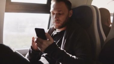 Mutlu rahat Avrupa serbest işçi rahat trende seyahat zevk smartphone messenger app kullanarak.