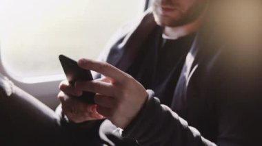Mutlu rahat Avrupa adam akıllı telefon messenger app tren pencere kenarı üzerinde seyahat mesajlar yazarak yakından görmek.