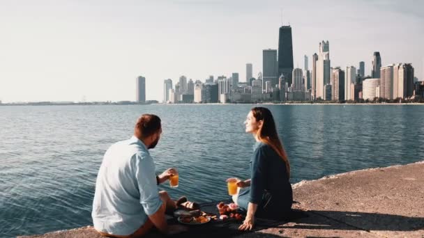 Pareja feliz disfrutando de hermoso paisaje de Chicago, América en la orilla del lago Michigan durante el picnic . — Vídeos de Stock