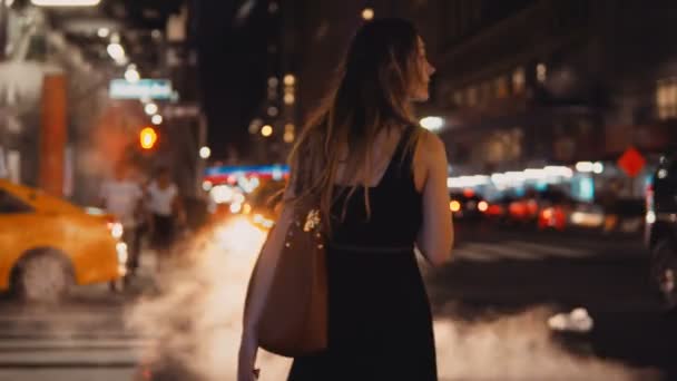 Vista trasera de la joven hermosa mujer de pie cerca del paso de peatones, carretera de tráfico en Nueva York, América del centro . — Vídeos de Stock