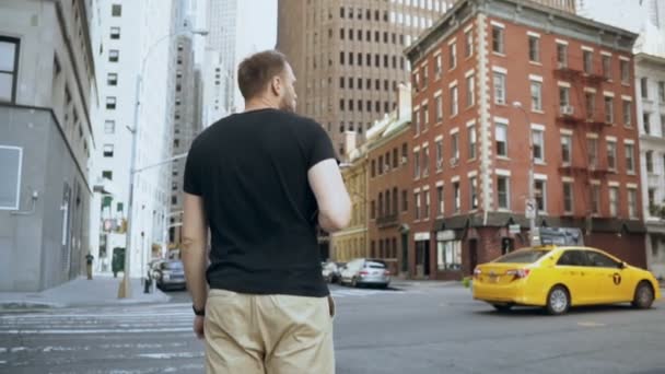 Jeune homme d'affaires beau avec des documents debout près de la route, allant travailler au bureau à New York, en Amérique. Mouvement lent . — Video