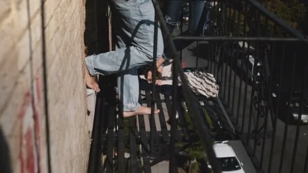 Joven pareja romántica multiétnica de pie juntos charlando en un pequeño balcón soleado con increíbles vistas a la ciudad de Nueva York . — Vídeos de Stock