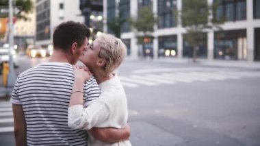 Sarılma ve öpüşme meşgul New York sokak kapısı yakınında duran erkek arkadaşı ağır çekim gülümseyen Genç beyaz kız.