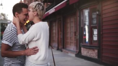 Ağır çekim mutlu Avrupa kız gülümseyerek, New York şehir akşam sokak boyunca yürüyüş zevk sevgilisi burun ısırma.