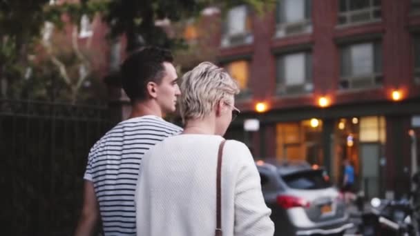 Slow motion happy young romantic couple talking while exploring beautiful streets of New York City, camera panning right — Stock Video