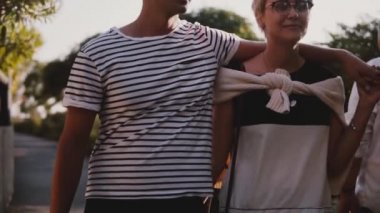 Ağır çekim mutlu kadın ve erkek birlikte birbirlerine sarılma ve bir güzel yaz gün batımı parkta konuşmak yürümek rahat.