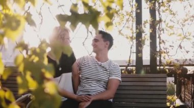 Yavaş hareket huzurlu romantik çift birbirine yakın bir sonbahar bankta oturan ve planlar ve rüyalar hakkında konuşmak.