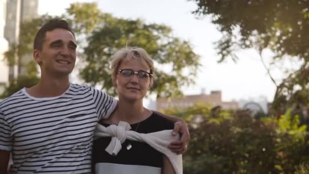 Lento movimento feliz sorrindo jovem hispânico homem e mulher europeia andar olhando uns para os outros em uma rua da cidade de verão . — Vídeo de Stock