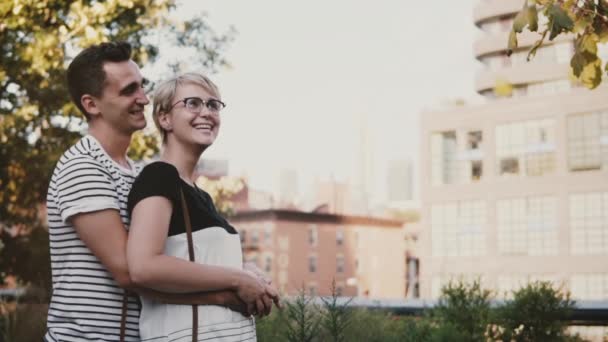 Slow motion relaxed romantic couple standing close together holding each other smiling and talking in a beautiful park. — Stock Video