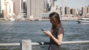 Uzun saçlı yürüyüş New York, telefon görüşmesi ve konuşurken Manhattan siluetinin güzel genç beyaz kız.