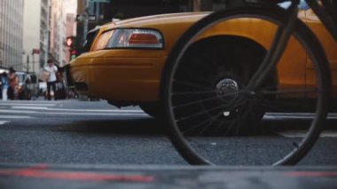 Duran, o zaman geçirerek meşgul sokak, bisikletli geçmeye başladılar ünlü New York sarı taksi taksi düşük açılı yan görünüm