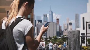 Güzel beyaz kız inanılmaz Manhattan Finans Merkezi panorama, New York City yakınındaki smartphone bakarak karıştı.