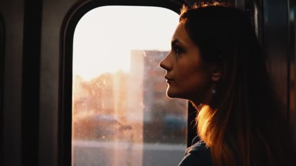 Portrait d'une jeune femme coûteuse prenant le métro à Chicago, en Amérique, au coucher du soleil. Triste femelle à l'intérieur du train en mouvement . — Video