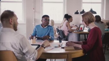 Avrupa kadın patron çalışanlara, türleri tablosu tarafından laptop kılavuzları verir. Office Toplantısında çok ırklı ekip çalışması.
