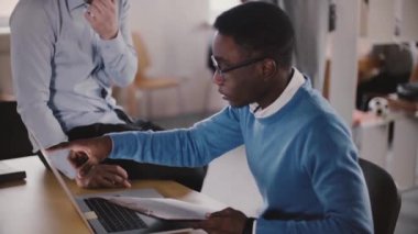 Afrikalı-Amerikalı genç meslektaşı modern ışık ağır çekim yakın çekim coworking, kendine güvenen erkek yönetici yardım