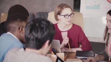 Başarılı güzel kadın Ceo çalışanlarla modern loft ofiste çok ırklı takım toplantısında konuşan iş kadını.