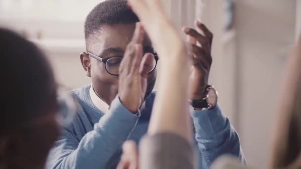 Felice uomo d'affari afroamericano di successo alzando e battendo le mani, celebrando il successo con il team in una riunione . — Video Stock