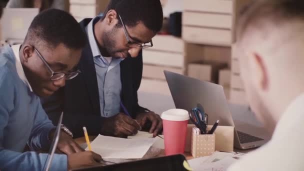 Multiethnische Geschäftsleute brainstormen gemeinsam bei Bürotreffen, schreiben in modernem Coworking auf Zettelchen. — Stockvideo