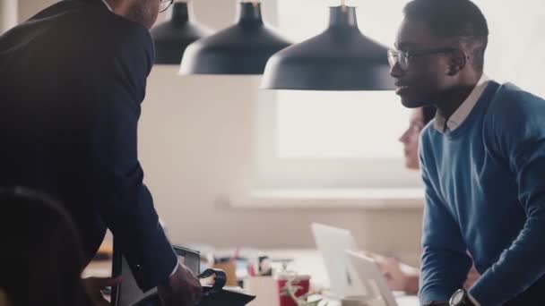 Funcionário afro-americano feliz senta-se na mesa de escritório, aperta a mão chefe, sorrindo, jogando com bola câmera lenta close-up . — Vídeo de Stock